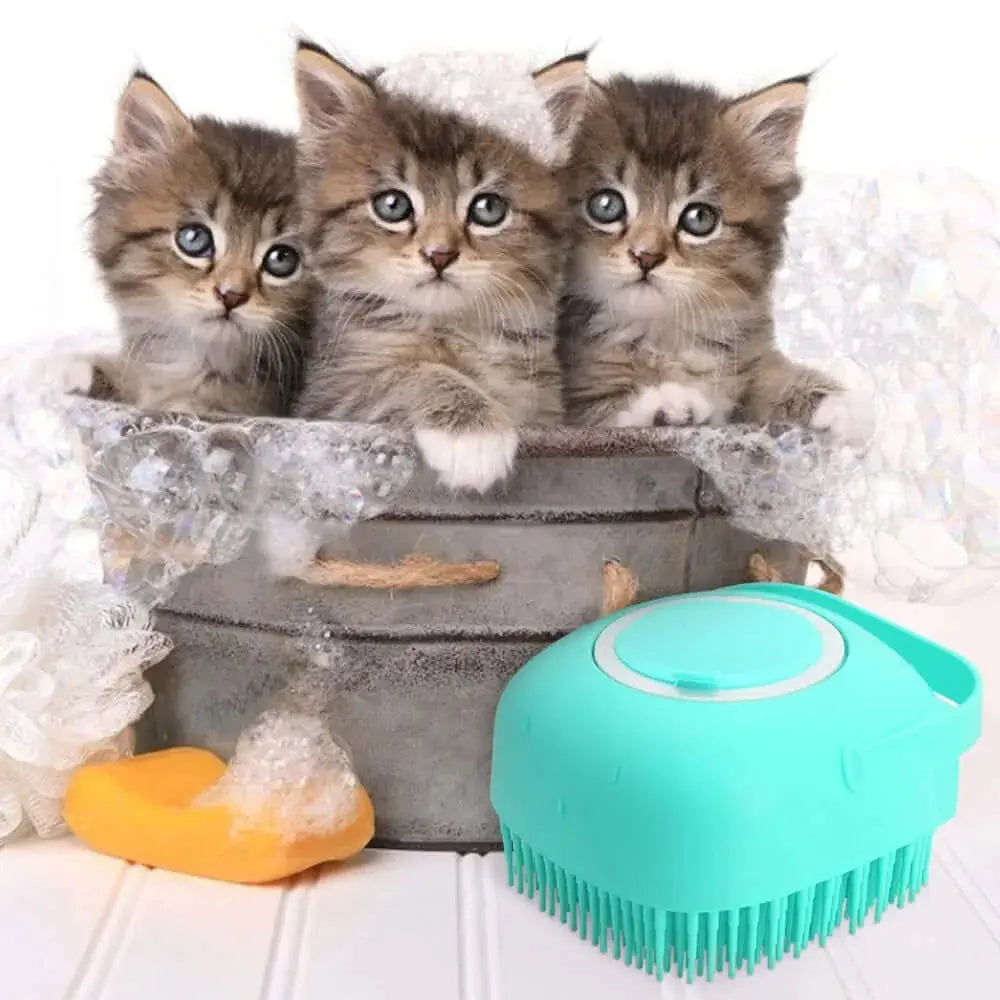 Three playful kittens in a bubble-filled tub with a teal silicone pet grooming brush for washing and massaging.