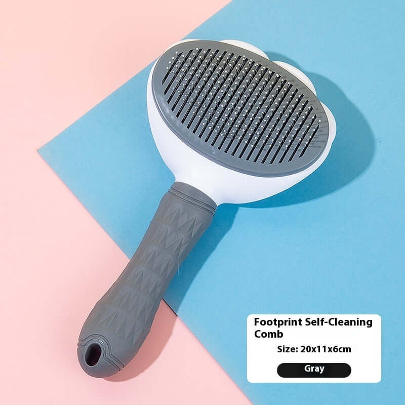 Footprint self-cleaning comb in gray on pastel background, ideal for pet hair removal and grooming.