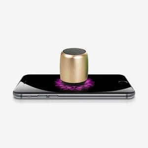 Compact portable outdoor mini speaker on a smartphone, showcasing wireless audio capability and modern design.