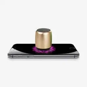 Nevytech Compact portable outdoor mini speaker on a smartphone, showcasing wireless audio capability and modern design.