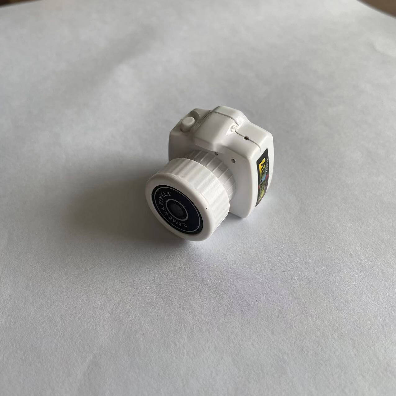 Mini white camera model side view on white background, ideal for photography accessories.