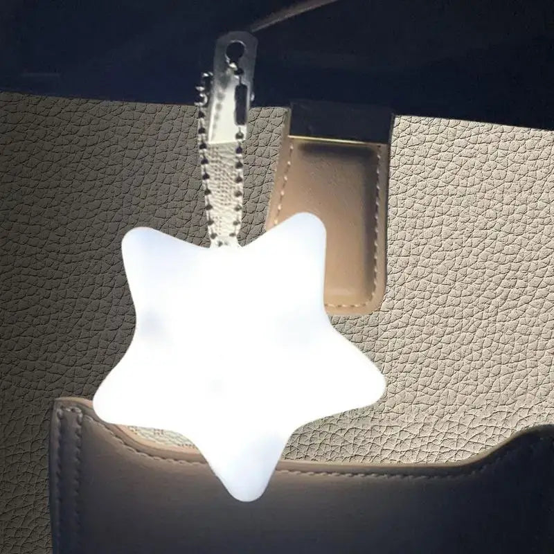 Star-shaped LED handbag light with keychain clip, designed for easy access inside bags, ideal for nighttime use.
