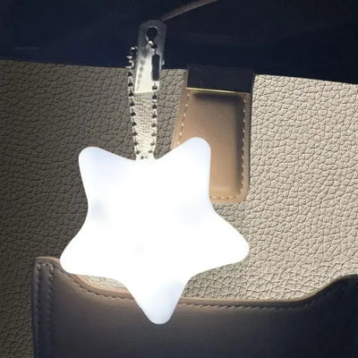 Star-shaped LED handbag light with keychain clip, designed for easy access inside bags, ideal for nighttime use.