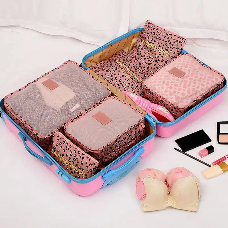 Open suitcase filled with colorful packing cubes for organized travel, including pouches for clothing and lingerie.