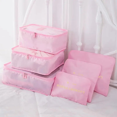 Set of pink travel luggage packing cubes for organizing clothes and accessories during travel.