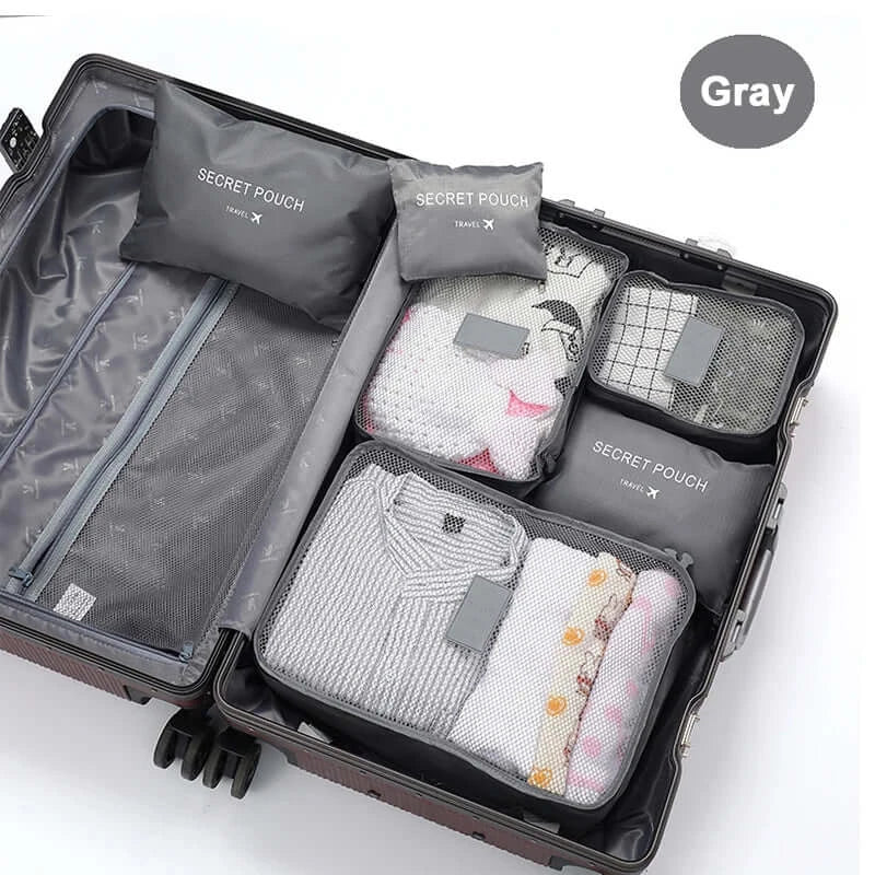 Organized travel luggage with gray packing cubes and secret pouches for clothes and accessories.