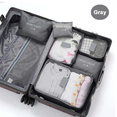Organized travel luggage with gray packing cubes and secret pouches for clothes and accessories.