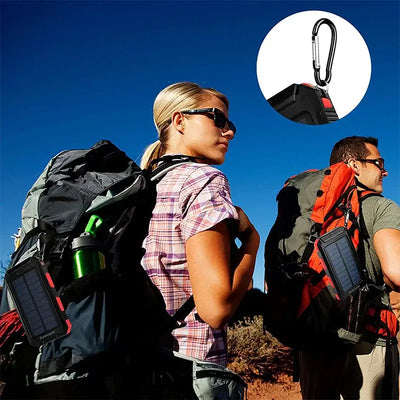Couple using a 20000mAh solar power bank outdoors, showcasing its portability and carabiner feature.