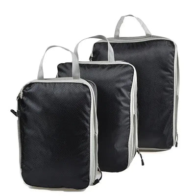Three foldable and compressible packing cubes in black with gray accents, perfect for travel organization.