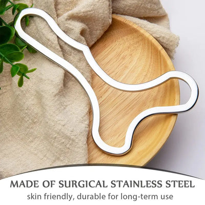 Stainless steel Gua Sha scraping tool on a wooden plate, designed for muscle relief and lymphatic drainage.