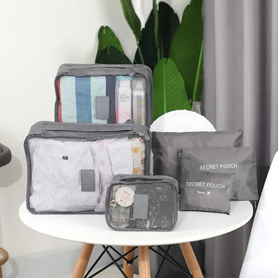 6-piece travel packing cube set organized on table, showcasing various sizes for clothing and accessories.
