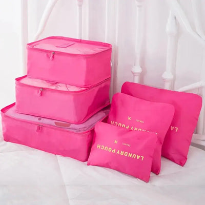 Set of pink travel packing cubes and pouches for organized suitcase storage