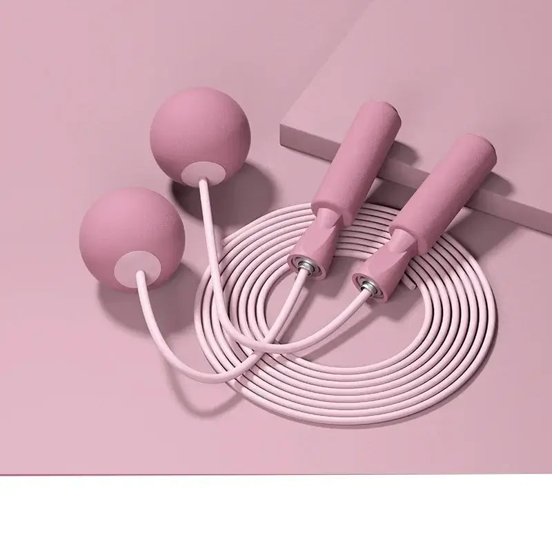 Pink cordless skipping rope with weighted balls and ergonomic handles for fitness training and aerobics.