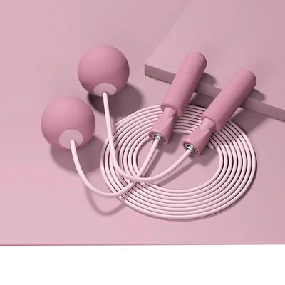 Pink cordless skipping rope with weighted balls and ergonomic handles for fitness training and aerobics.