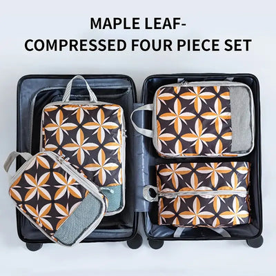 Maple leaf design four-piece compressed storage set inside an open suitcase, perfect for travel organization.