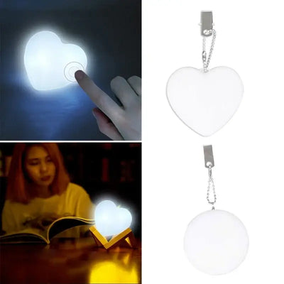 Heart-shaped LED handbag lamp with automatic motion activation, glowing in a cozy setting while being used as a charm.