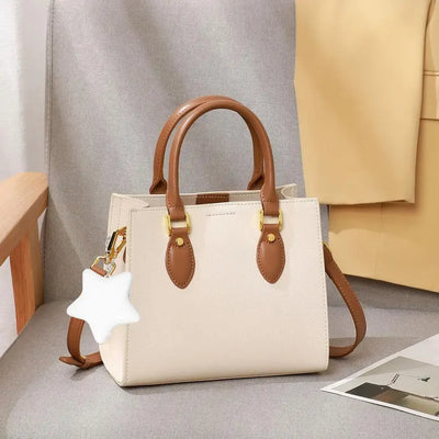 Stylish beige handbag with brown handles and a star-shaped keychain light, perfect for night outings.