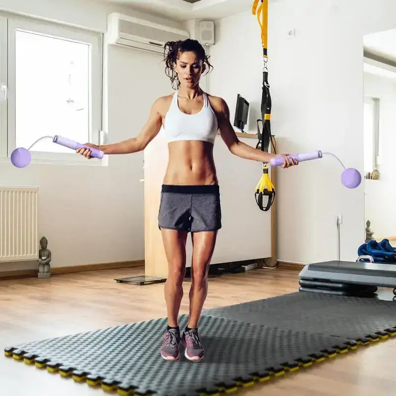 Woman exercising with a ropeless jump rope in a bright indoor gym, showcasing a solid grip and adjustable design.