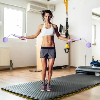 Woman exercising with a ropeless jump rope in a bright indoor gym, showcasing a solid grip and adjustable design.