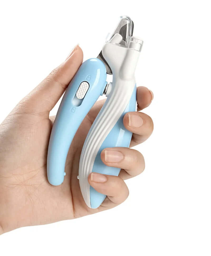 Hand holding LED pet nail clippers designed for safe and easy trimming of small pets' nails.