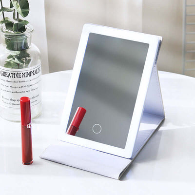 Portable LED makeup mirror in white with red lipstick, perfect for dressing rooms, featuring a folding design.